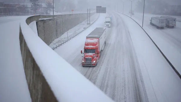 Semi trucks drive through the snow along I-264 on January 5, 2025 in Louisville, Kentucky.