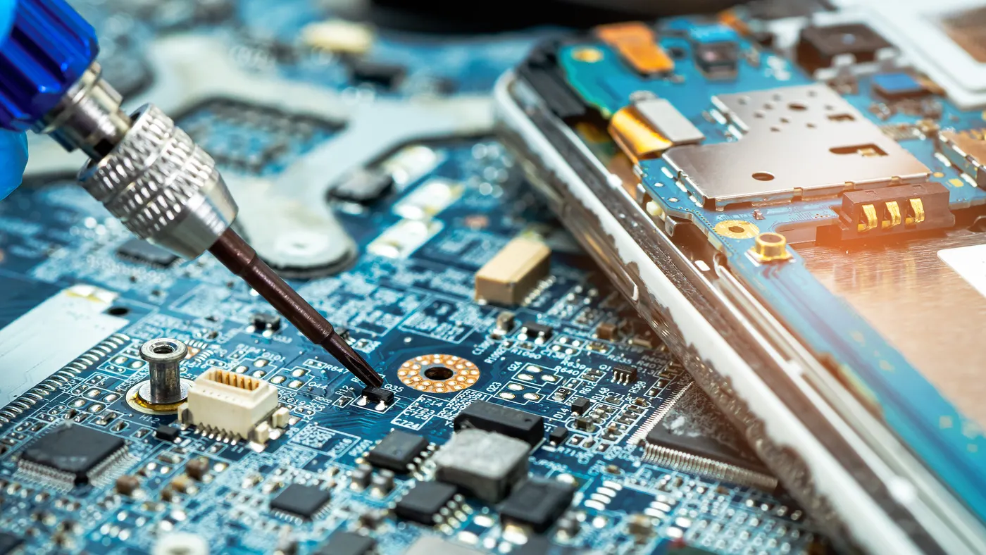 A close up of a tool touching the inside of a hard disk for repair