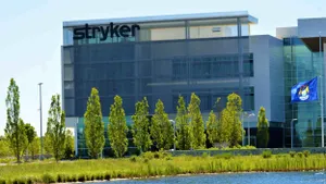 A picture of a large building with the name "Stryker" across it and a pond with a swan in the foreground.