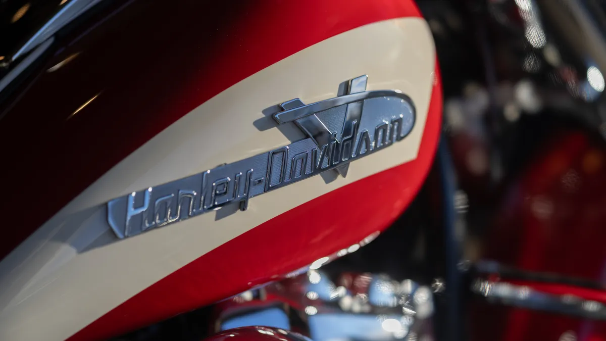 A silver Harley-Davidson logo on a red and white motorcycle.