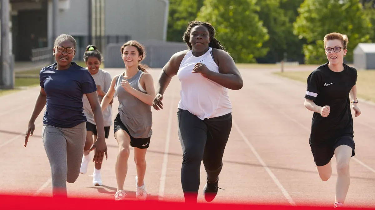 A group of teens race each other on a track