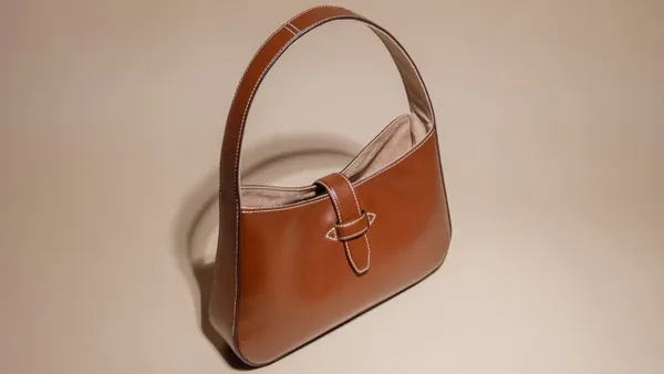 A handbag made with Faircraft leather sits on a lighted platform.