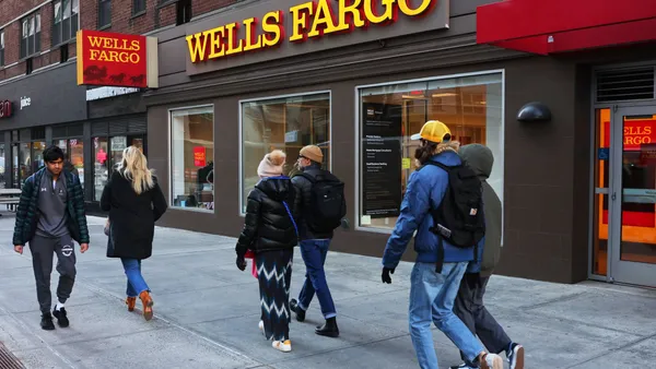 Pedestrians pass by a Wells Fargo bank branch.