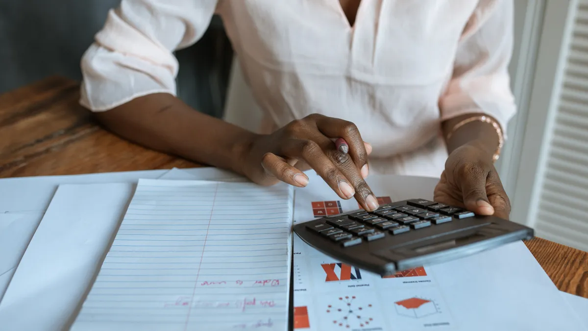 Person in white dress shirt using a calculator