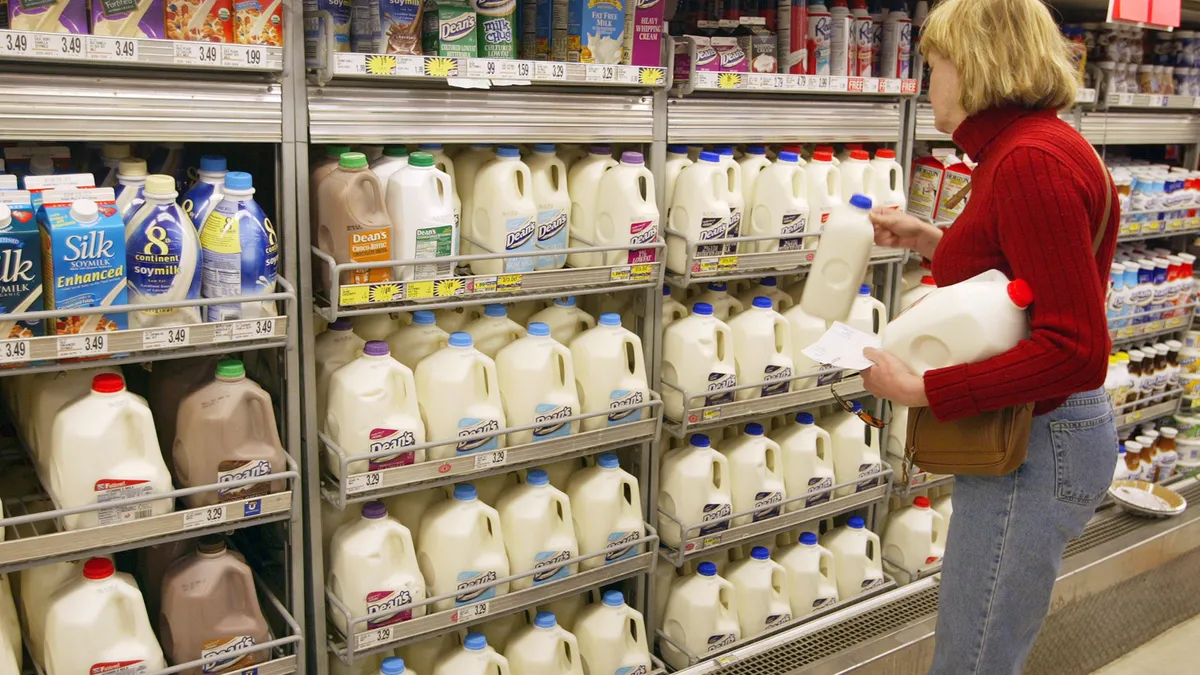 A woman shops for milk in a grocery store