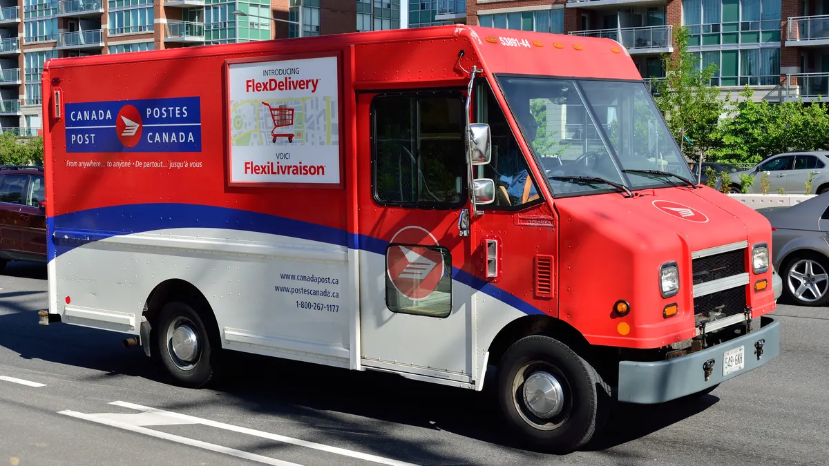 A Canada Post delivery truck on the road.