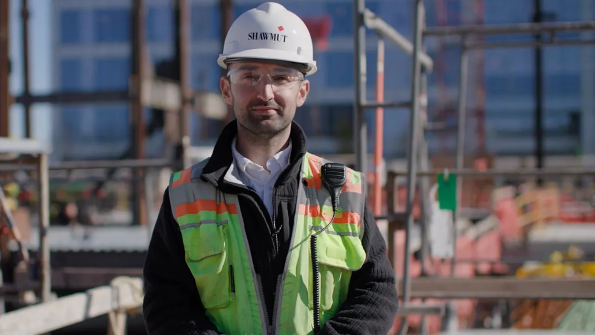 Happy guy in Shawmut construction gear standing outside