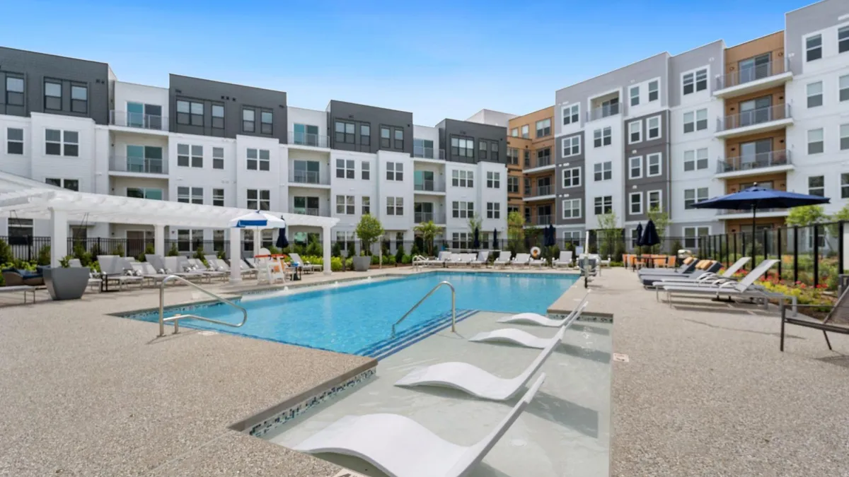 Pool surrounded by new, white apartments