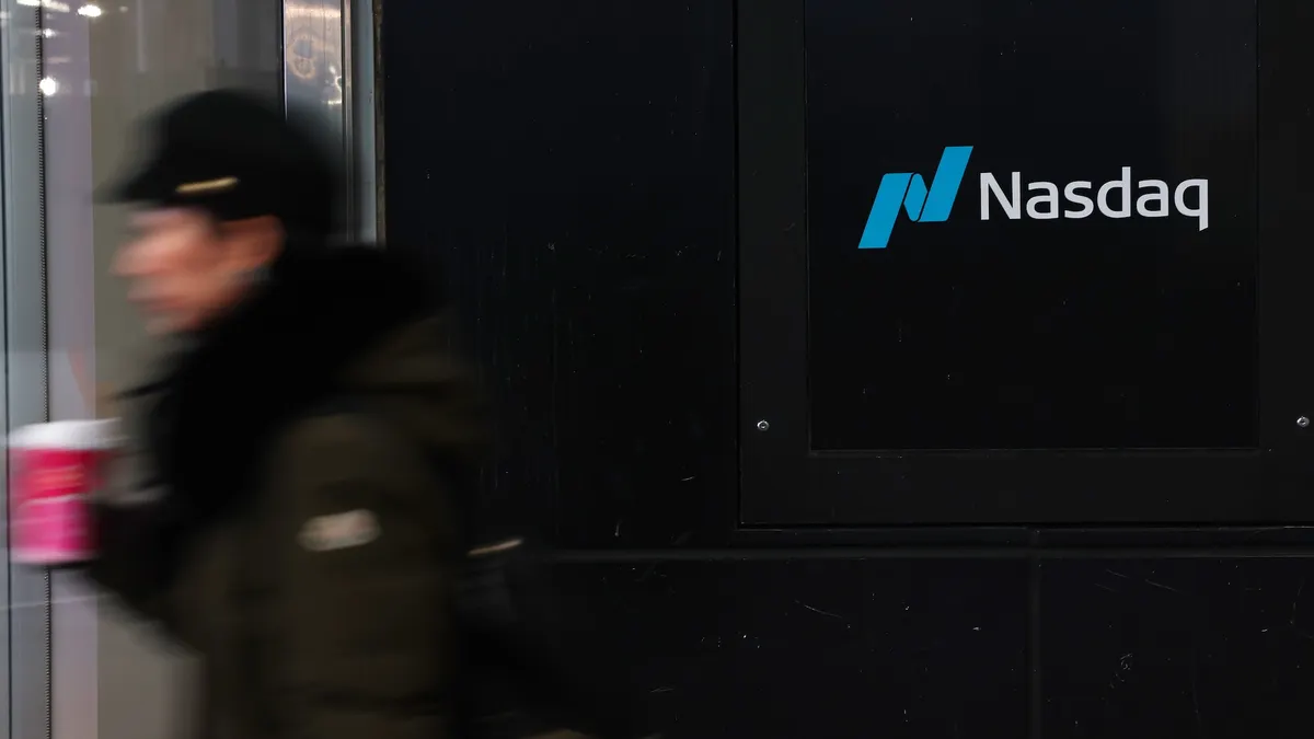 A man passes by the Nasdaq MarketSite sign.