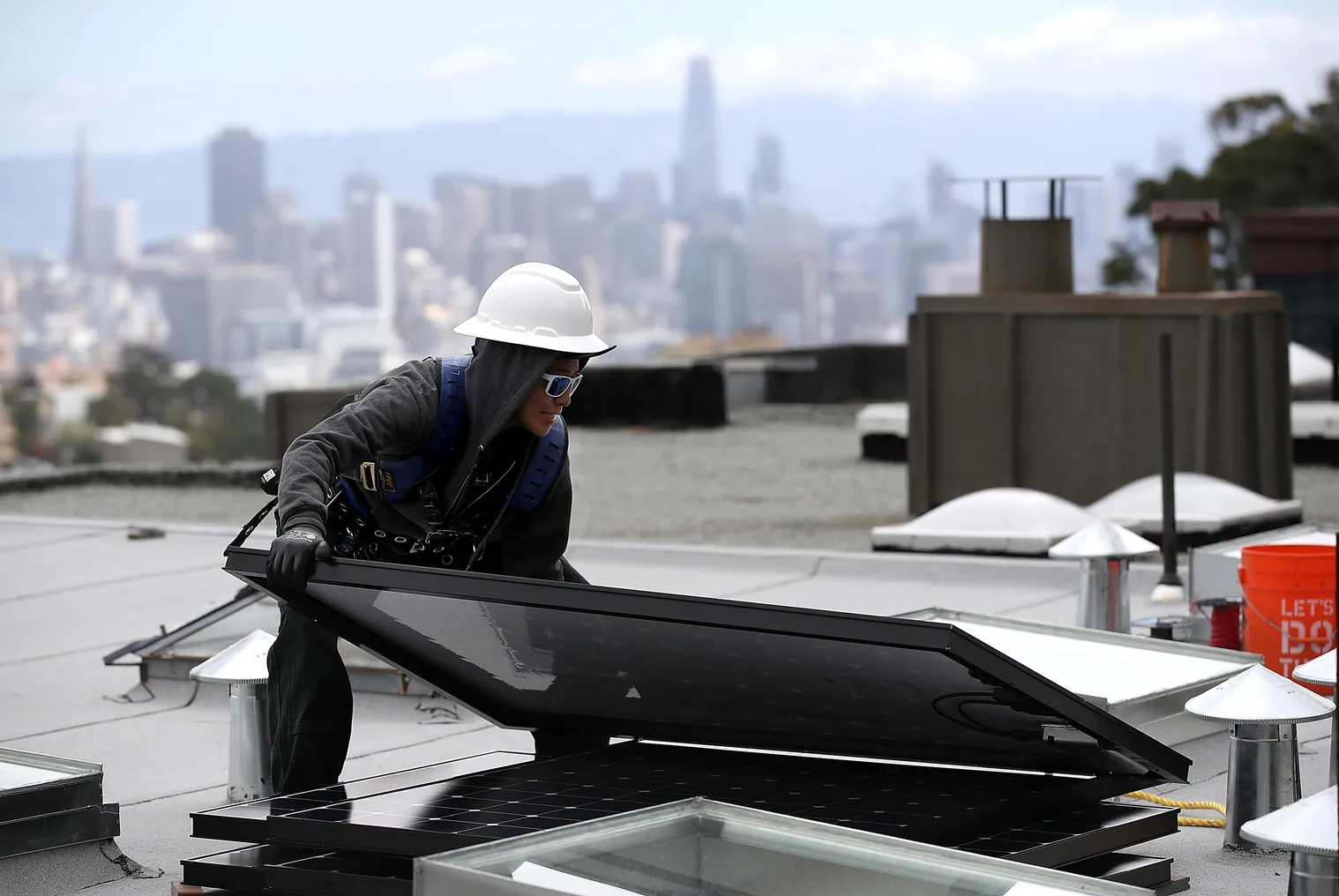 Luminalt solar installers Pam Quan moves a solar panel during an installation on the roof of a home on May 9, 2018 in San Francisco, California.