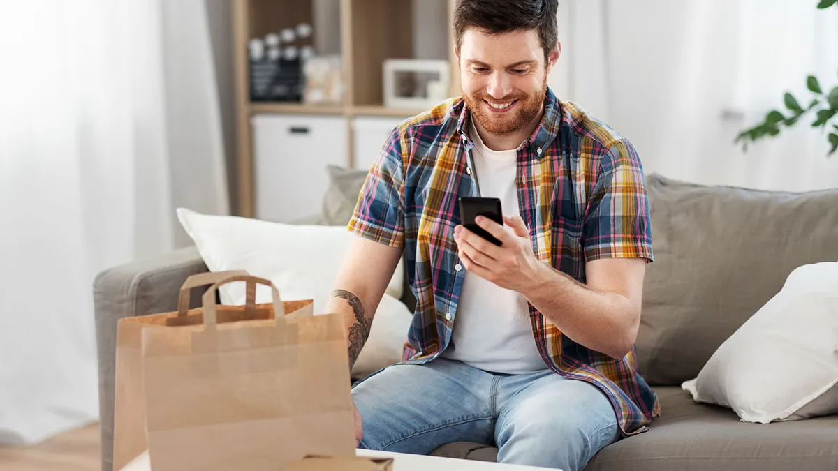 A photo of a person looking at a phone while sitting on a couch in a living room.