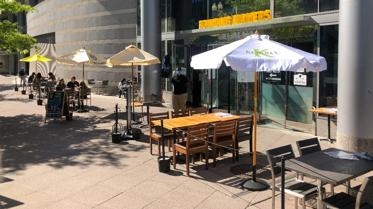 Customers at Founding Farmers in DC sit at outdoor dining tables days after the restaurant's windows sustained damage following local protests against systemic racism.