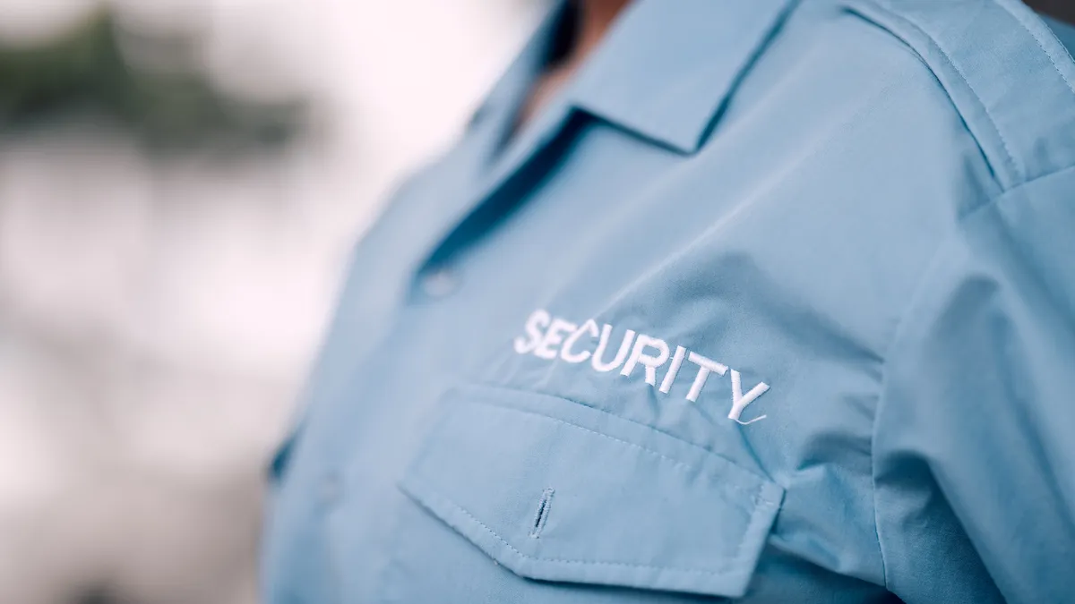 A guard wearing a uniform printed with the word "security"