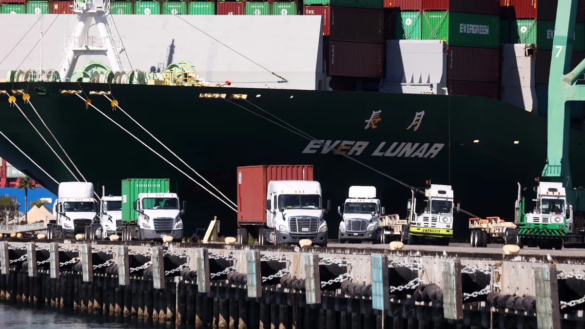 Trucks haul shipping containers at the Port of Los Angeles