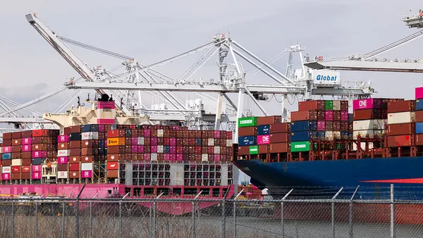 Two ocean vessels being unloaded and unloaded with containers.