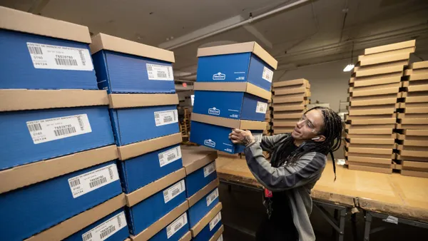A person stacks boxes on a pallet at a Baker Industries location