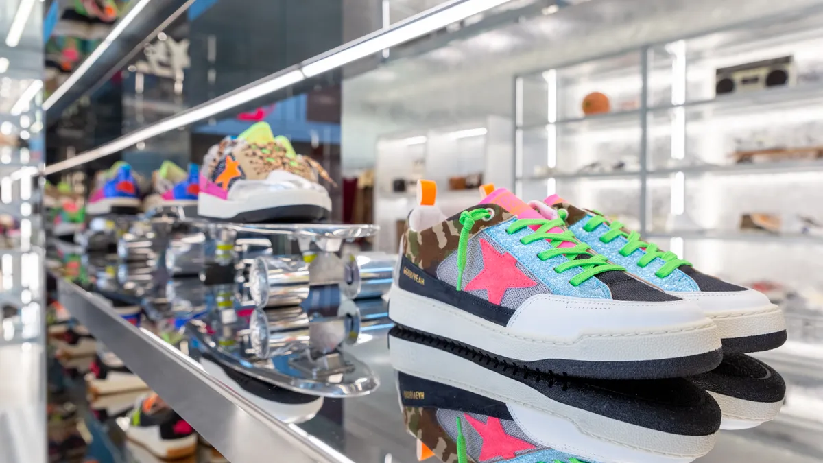 Golden Goose sneakers in bright colors are pictured on a store display.