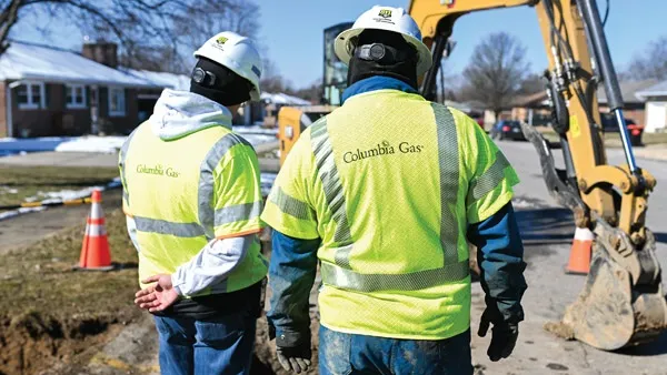 Men look at gas pipeline work.