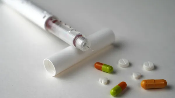A picture of tablets and injectable medicines for obesity.