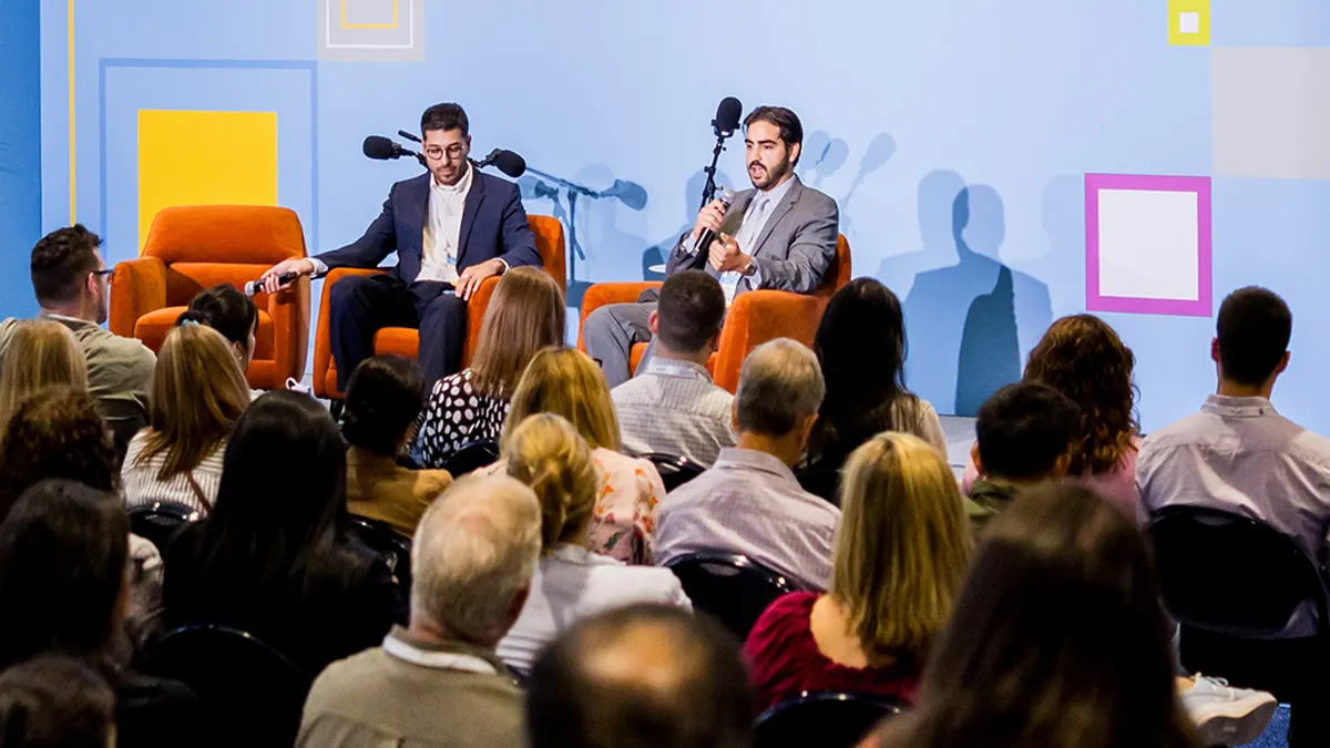 Two men speaking in a panel