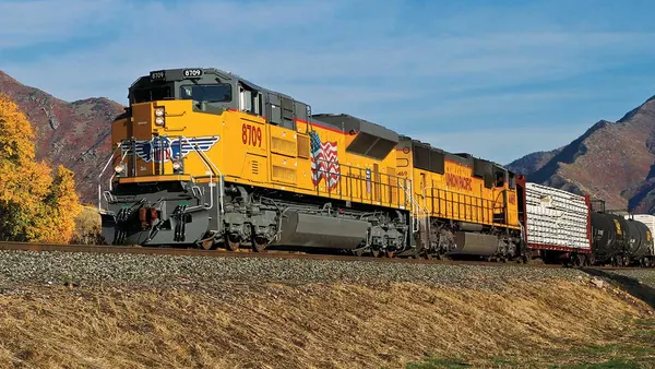 A rail train passing though a railroad track.