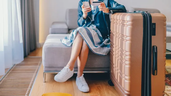 Woman paying on smartphone in hotel room