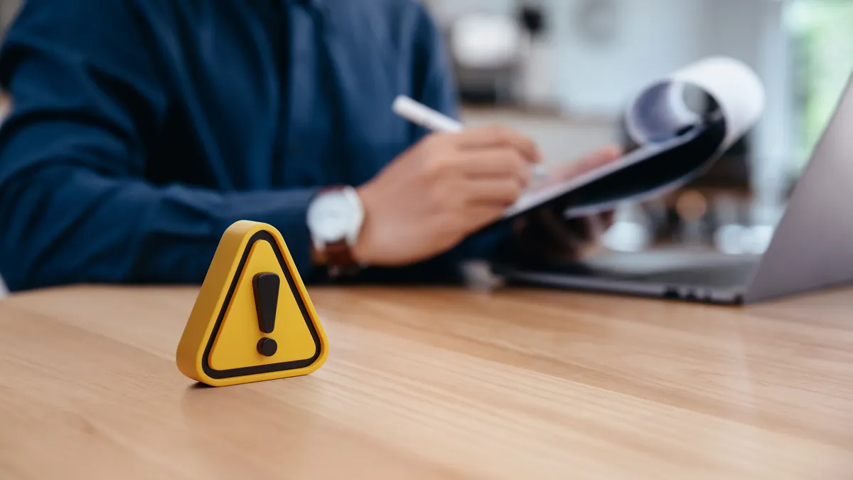 Warning sign on table in front of business person
