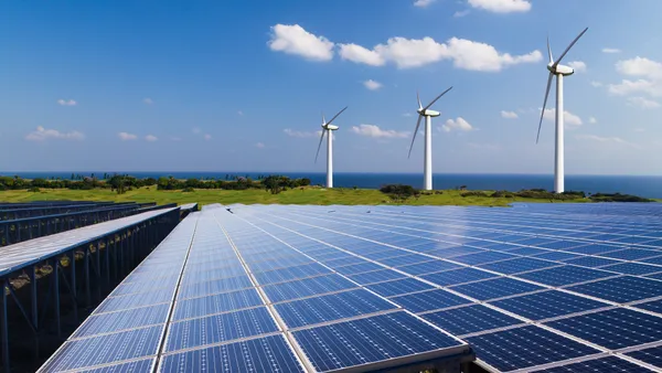 Solar panels and wind turbines in a field