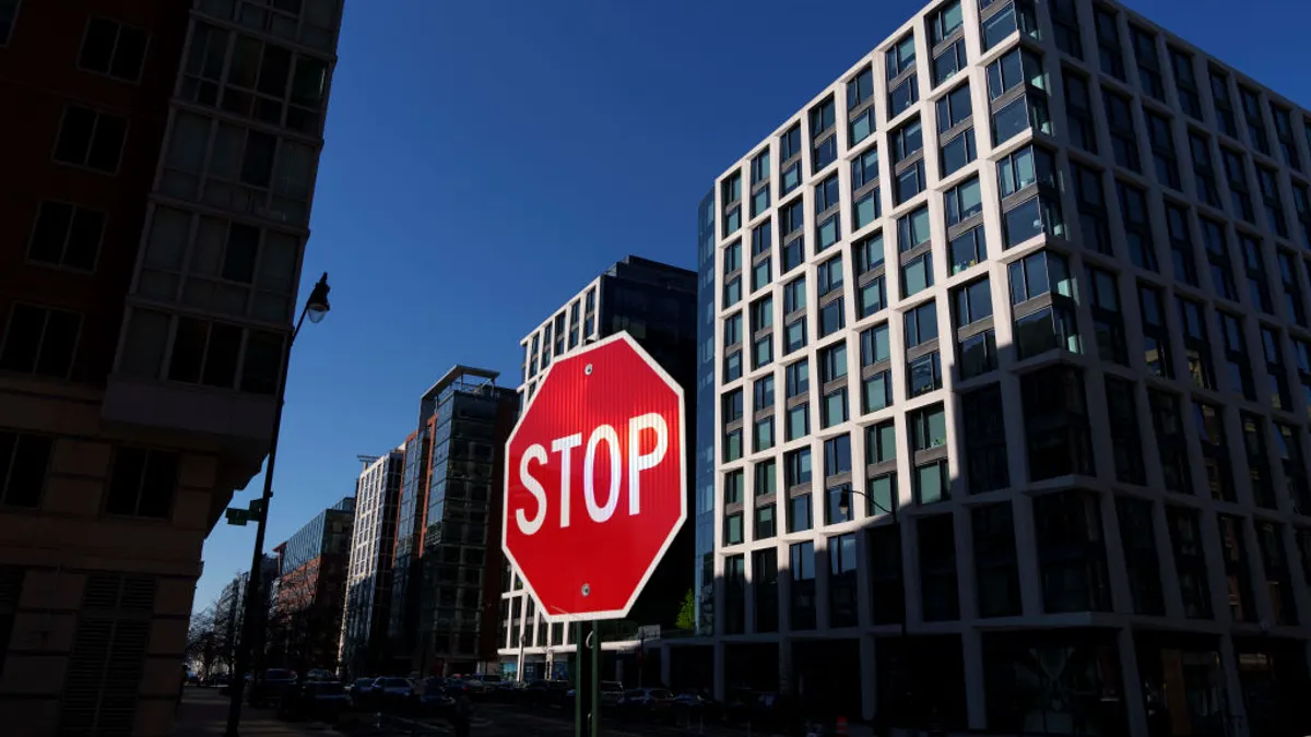 Tall apartment buildings in washington, dc with a stop sign in the foregound.