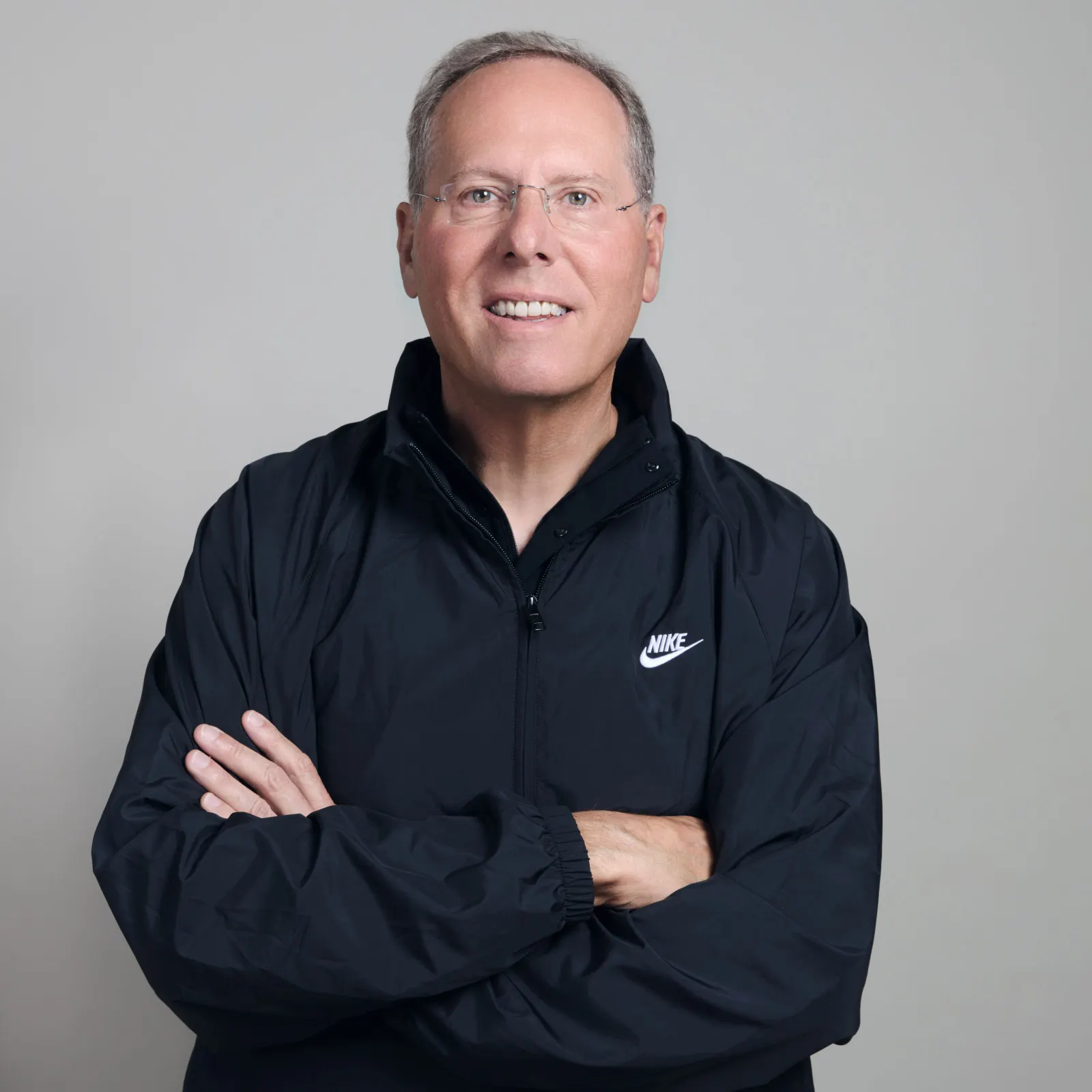 A headshot of Nike CFO David Denton in a black Nike jacket.