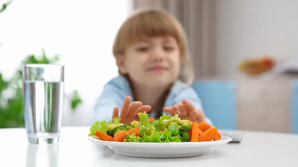 Small child refusing to eat vegetable salad