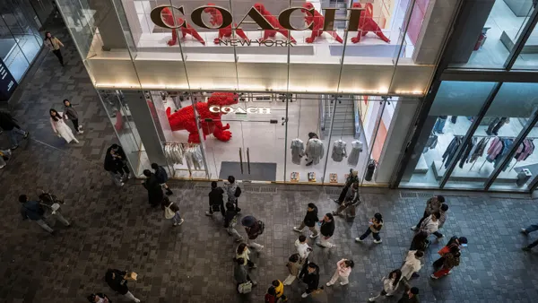 A Coach retail store as seen from above, with people walking by on the street below.