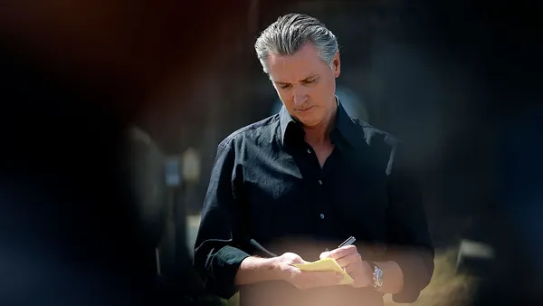 California Governor Gavin Newsom takes notes during a news conference at Gemperle Orchard on April 16, 2025 in Ceres, California.