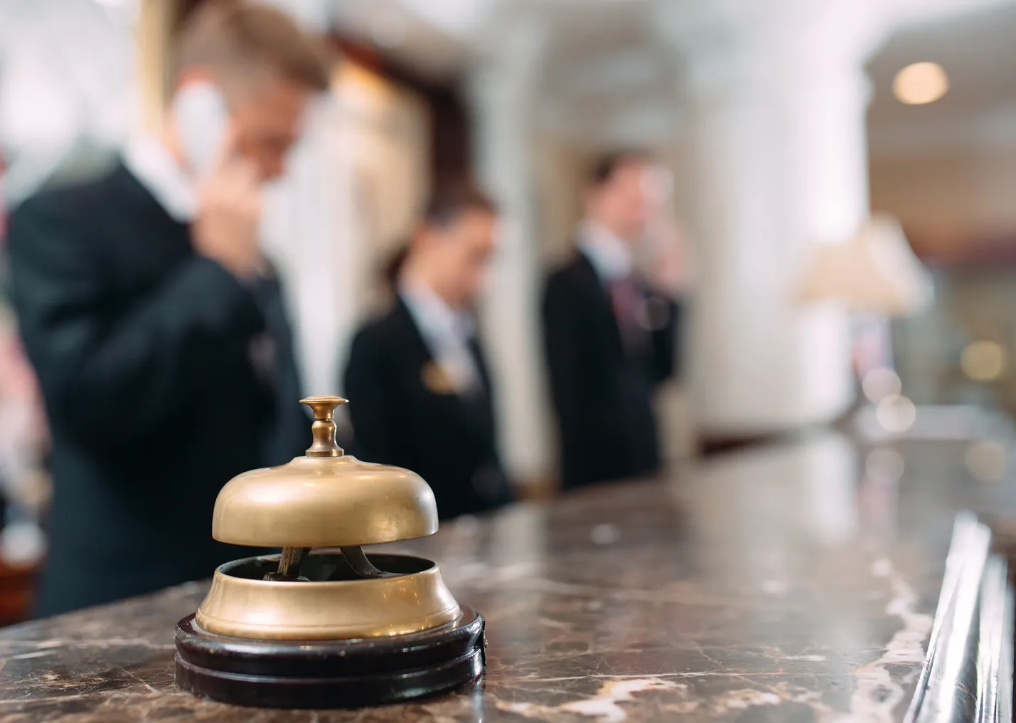 An image of a hotel front desk with staff blurred in background