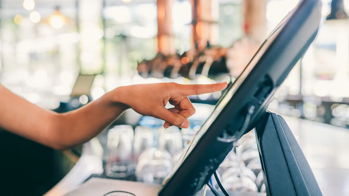 A worker keys information into a point of sale screen