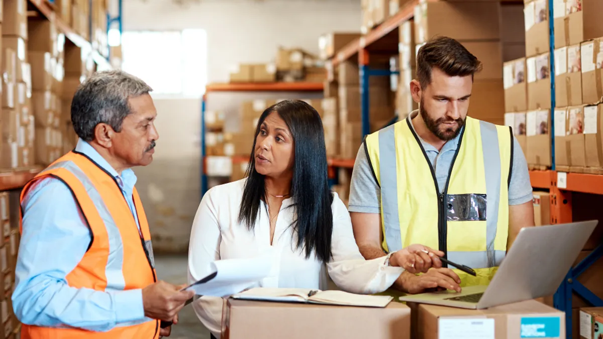 Workers with laptop and inventory behind them