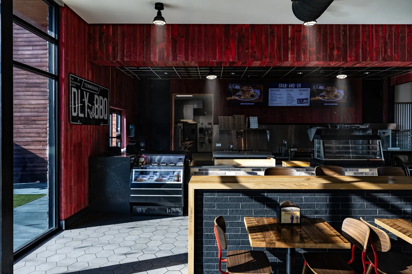 A photo of a barbecue counter inside a store. A sign on the wall reads DLY BBQ