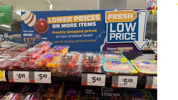 A sign advertising low prices for produce at a grocery store.