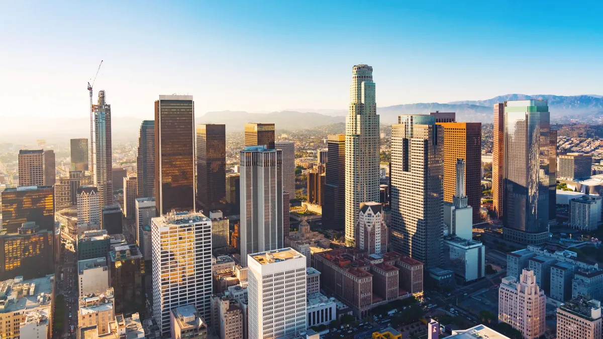 An aerial view of buildings and skyscrapers in downtown Los Angeles at sunset