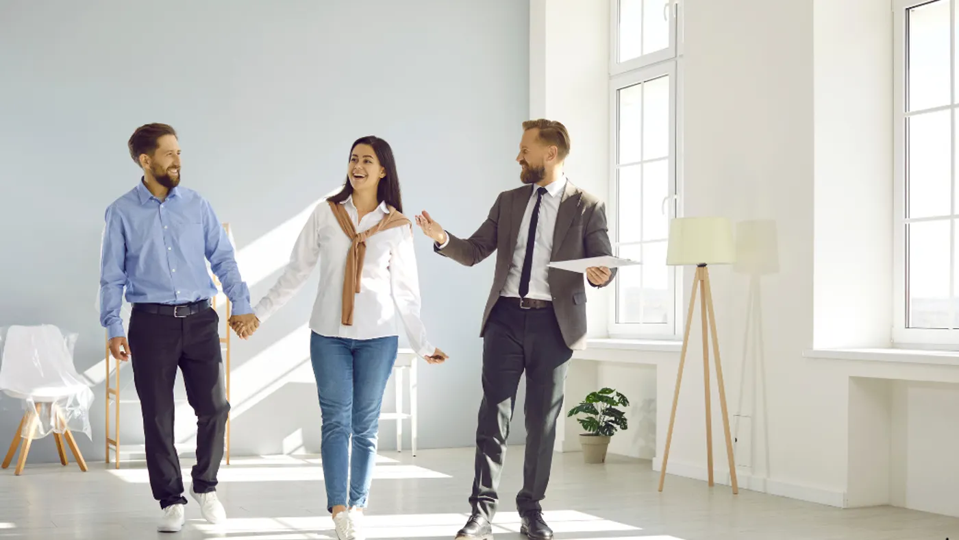 Three people walking in a room having a conversation.