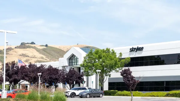 The Stryker logo is displayed on an office building with hills in the background.