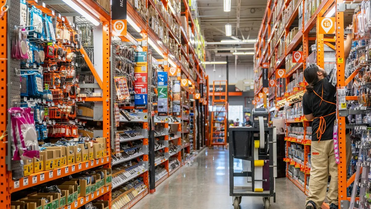 An associate stocks a shelf at a Home Depot