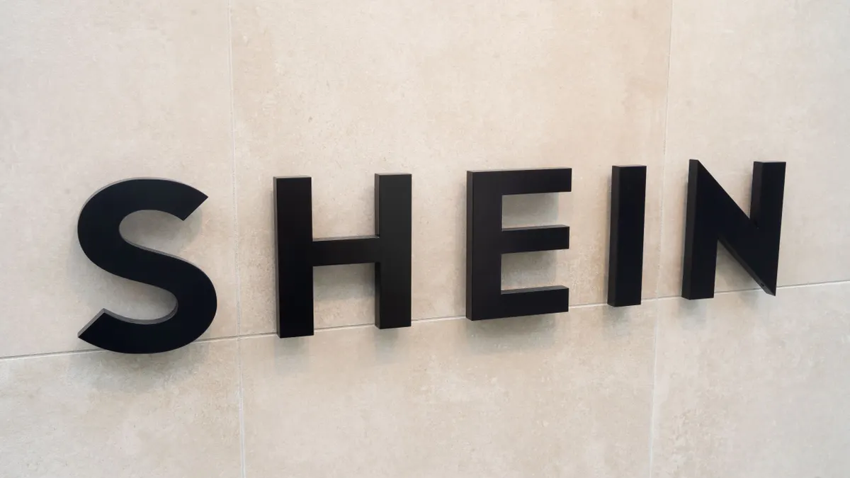 A closeup of a Shein sign on a wall.