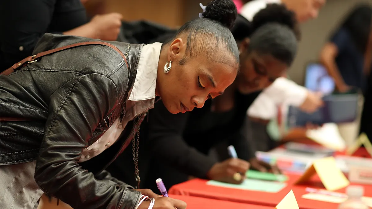 A woman fills out a form during a job fair event.