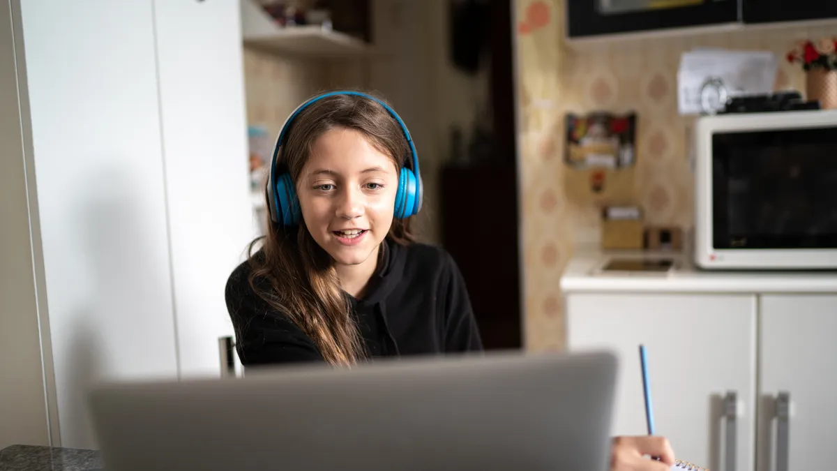 Girl studying and making a video call via laptop at home