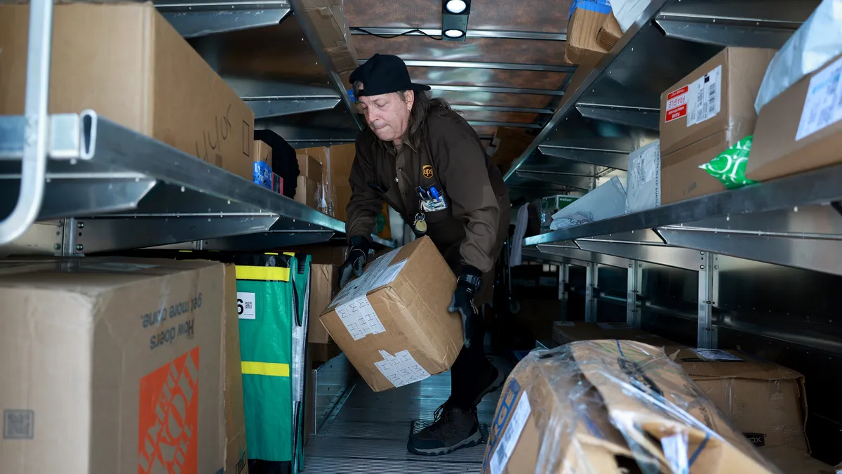 A UPS driver makes a delivery on June 30, 2023 in Miami, Florida.