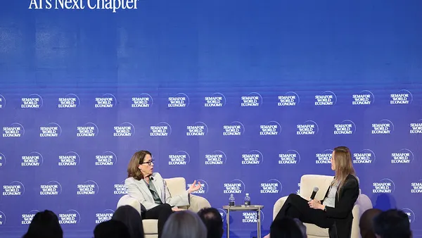 two women sitting in chairs on a stage