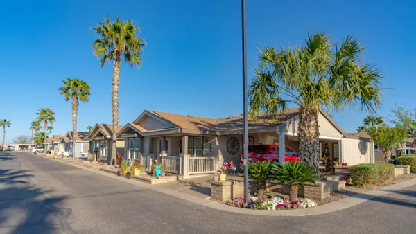 Single-level homes next to a street and palm trees