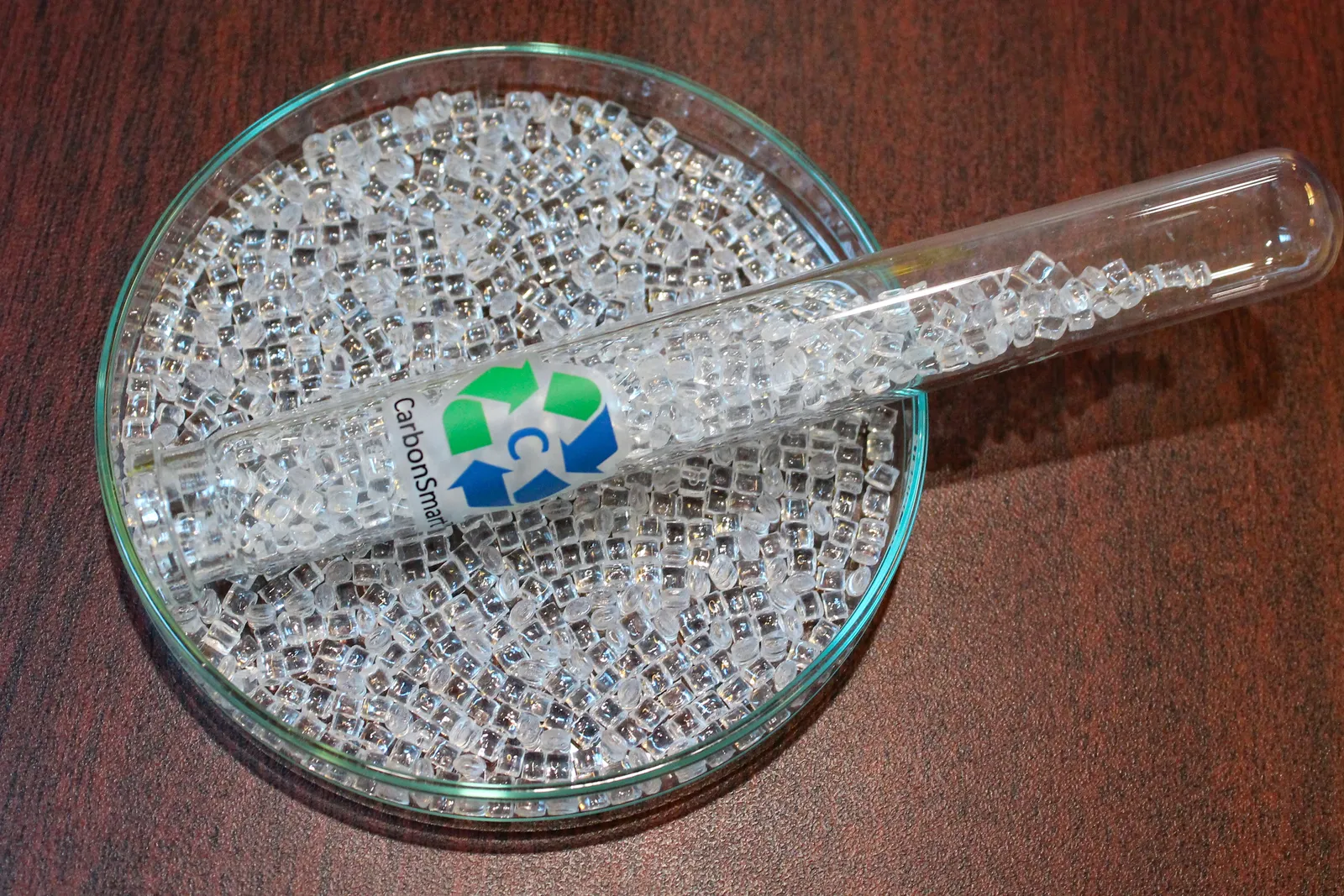 A petri dish and a test tube containing clear PET plastic pellets.