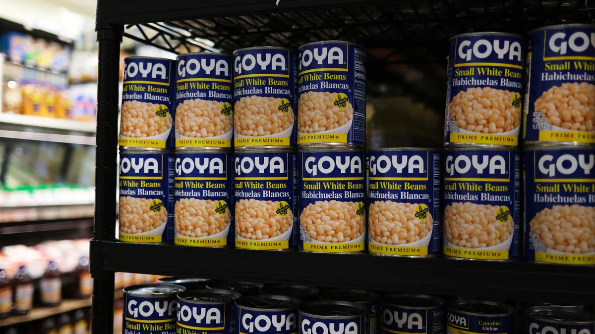 Cans of Goya white beans on a shelf